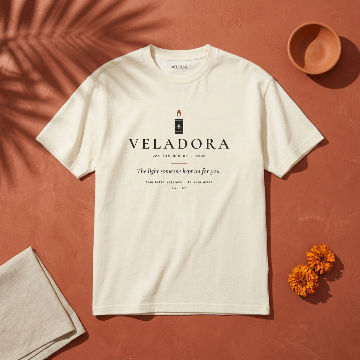VELADORA Palabra Tee in Faded Cream: garment-dyed heavyweight cotton tee printed with a prayer candle and the line “The light someone kept on for you.”