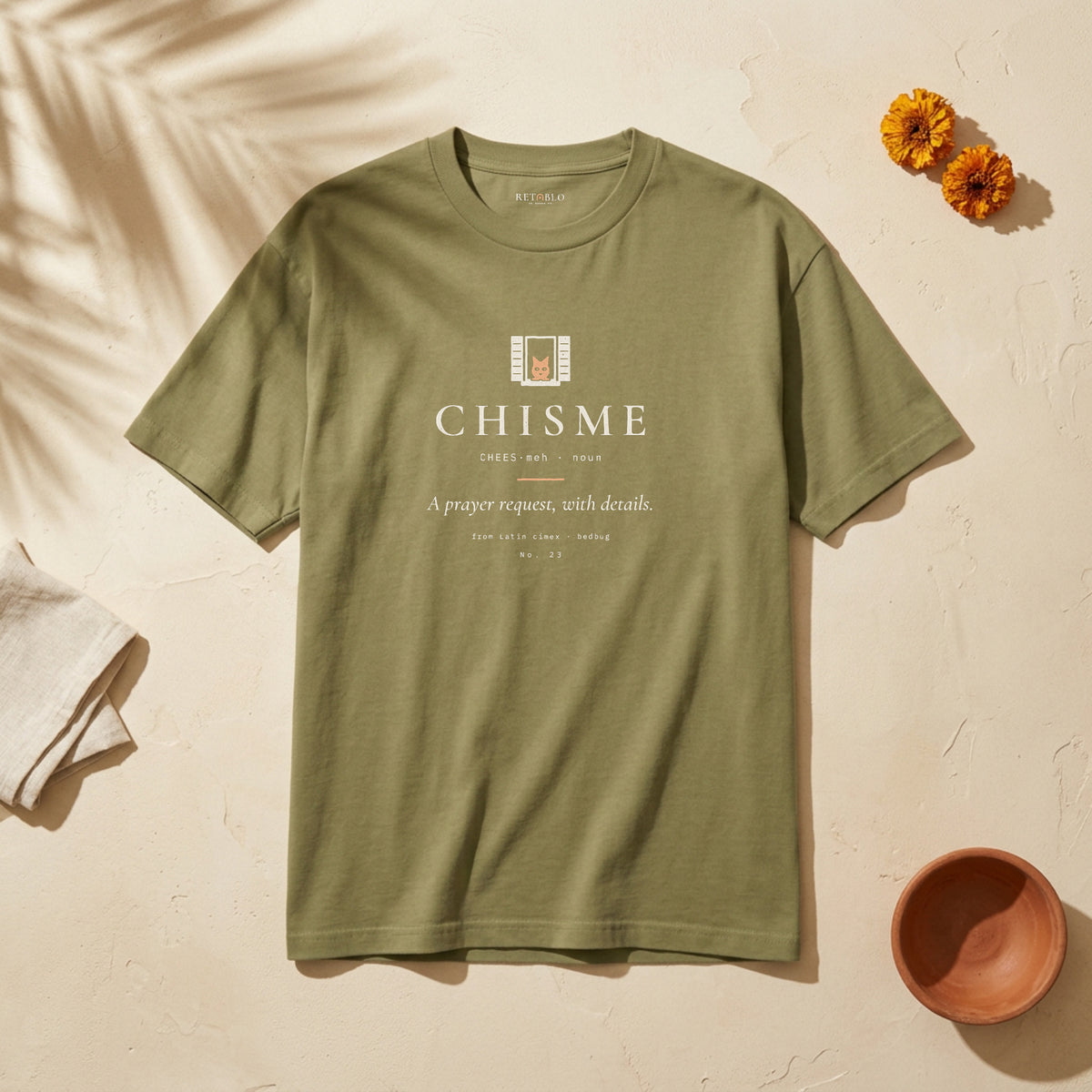 CHISME Palabra Tee in Faded Army: garment-dyed heavyweight cotton tee printed with a cat at the window and the line “A prayer request, with details.”